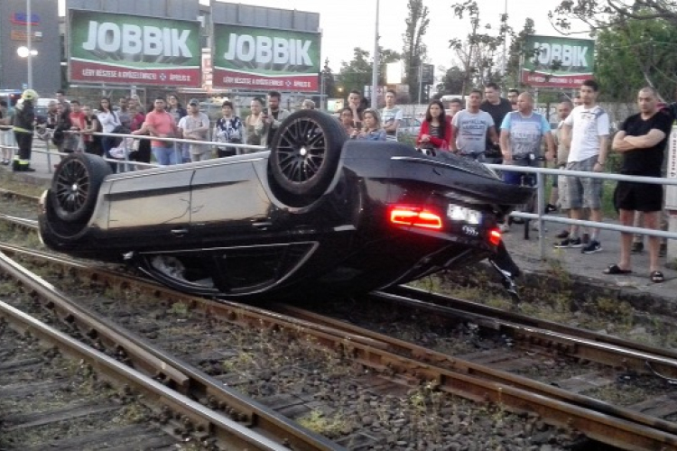 Szörnyű baleset: Hatalmasat repült az Audi, majd a vonatsíneken fejreállt